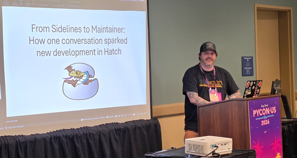 Cary Hawkins presents on Hatch in the Tools Track at the PyCon US Maintainer Summit in Long Beach, standing at a podium beside a slide titled From Sidelines to Maintainer: How one conversation sparked new development in Hatch.